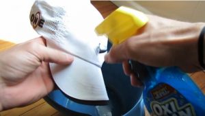 cleaning a white baseball hat